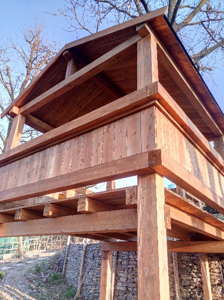 pedana rialzata su colonne con balconata e copertura in legno